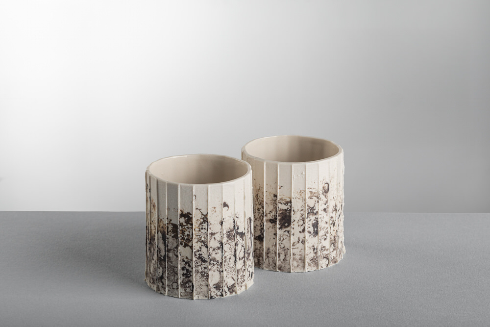 Due bicchieri in ceramica a coste verticali con smalto maculato scuro nella parte bassa