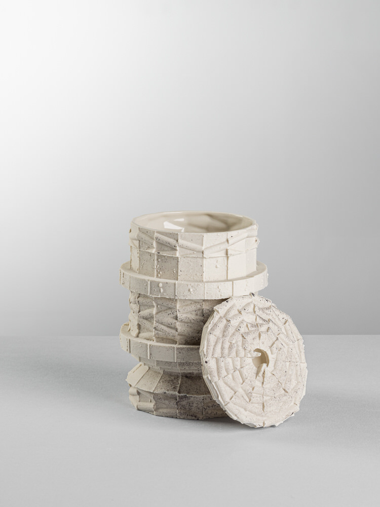 Barattolo in ceramica scolpita a mattoni con coperchio a spirale appoggiato di lato