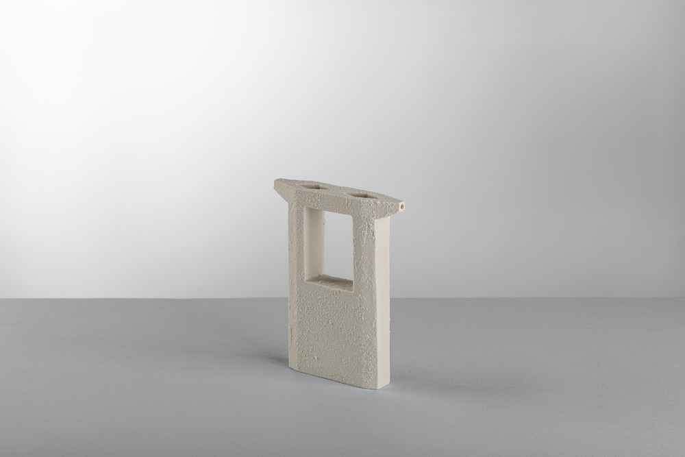 Vaso soliflore scultoreo in ceramica bianca con apertura passante e superficie opaca