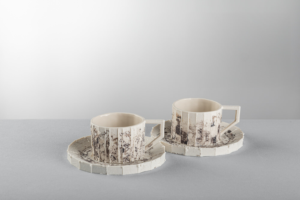 Due tazze da tè in ceramica con piattino, coste verticali e smalto maculato scuro