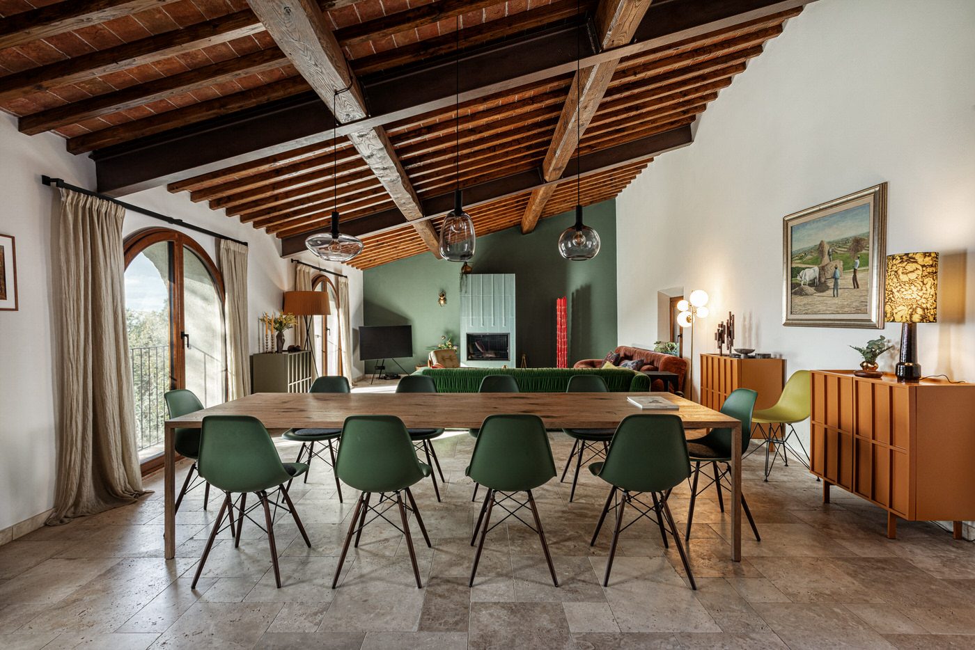 Interno di un edificio storico restaurato: sala da pranzo con soffitto a travi e sedie di design