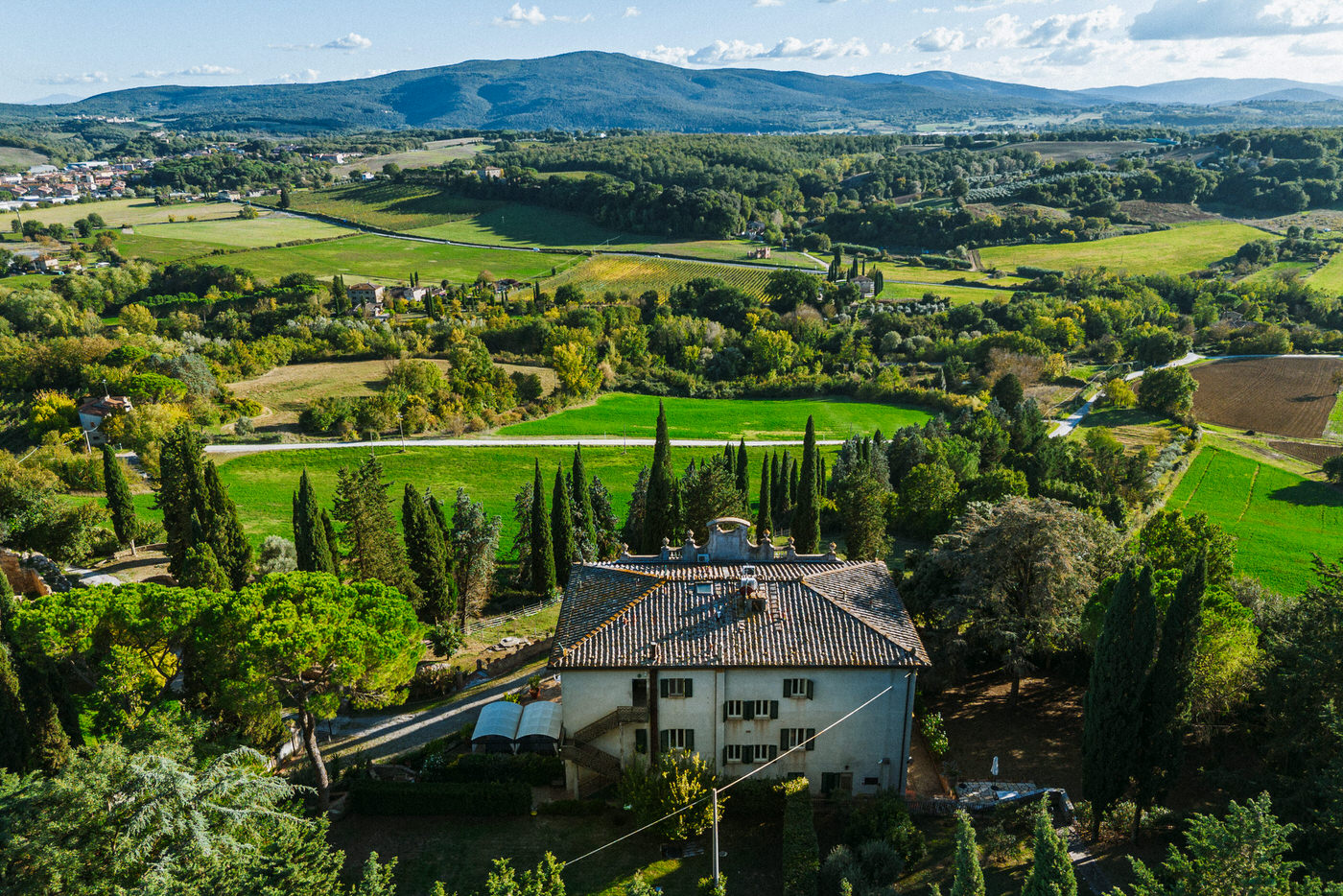 Villa storica vista dall'alto tra cipressi e la campagna collinare tra Firenze e Siena